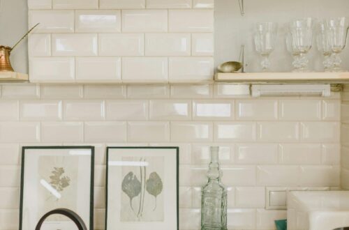 Stylish minimalist kitchen features stove, kettle, plants, and decor in serene setting.