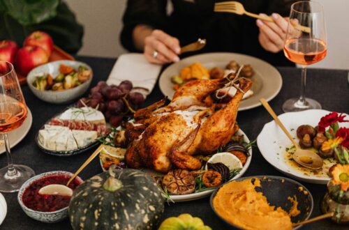A festive Thanksgiving dinner spread featuring a golden roasted turkey, vegetables, and wine, perfect for holiday dining.